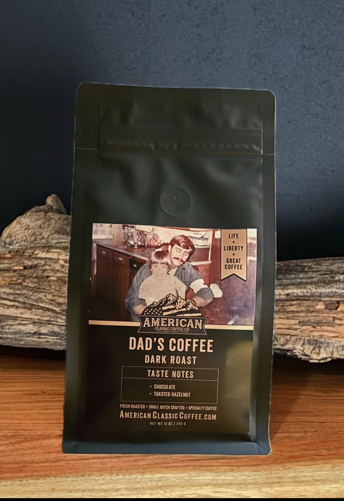 Bag of American Classic Dad's Coffee Dark Roast behind a log.